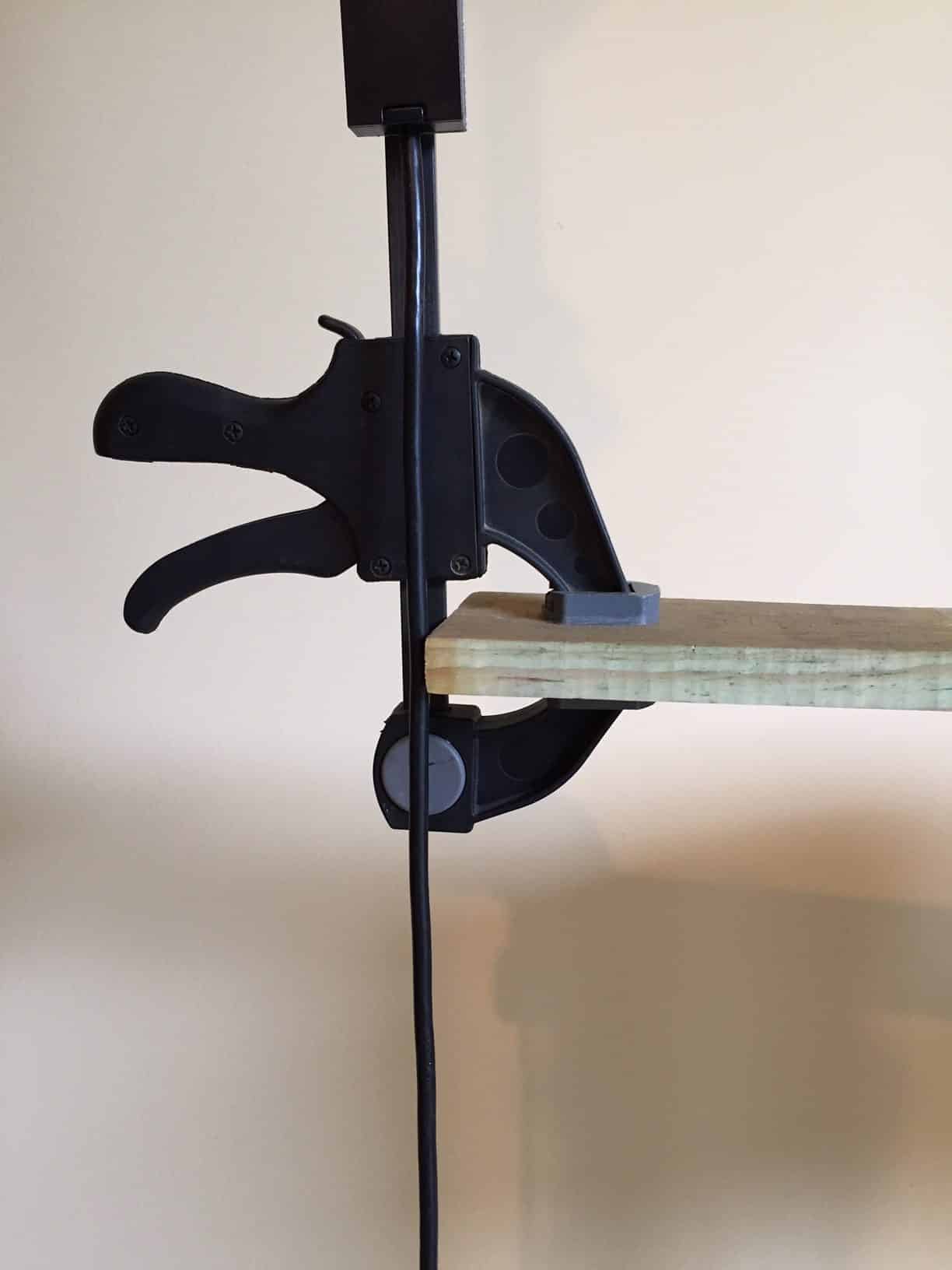 Close-up of the heavy-duty spring clamp gripping a display fixture edge
